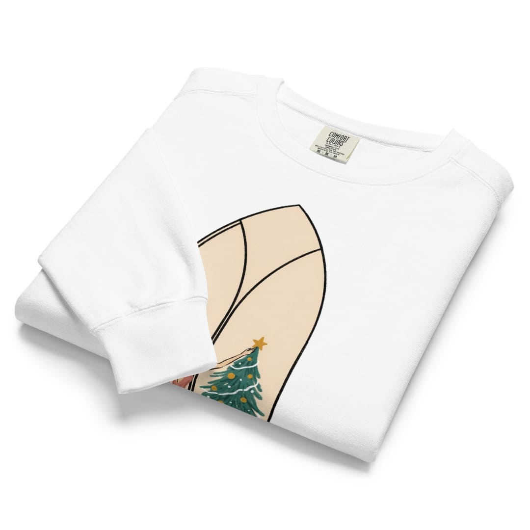Star of the Season™ sweatshirt by Blossombless.co in White, neatly folded to show the garment-dyed fleece and a soft pastel illustration of a woman in a backless rose gown placing a gold star on a Christmas tree, framed inside an ivory gothic arched window