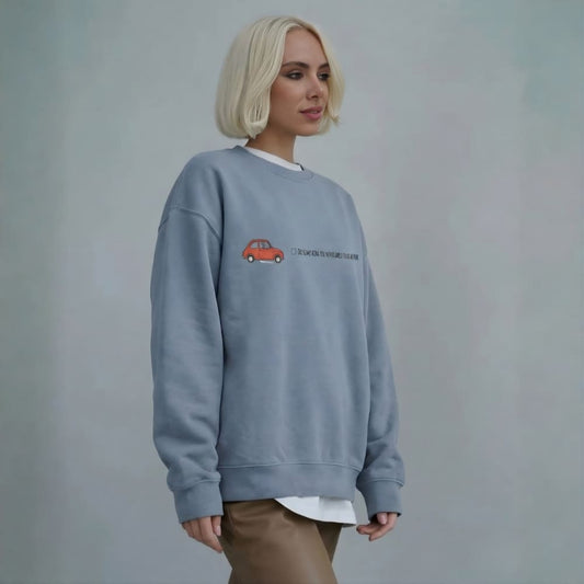 Person wearing a blue sweatshirt with a red car design on a plain background