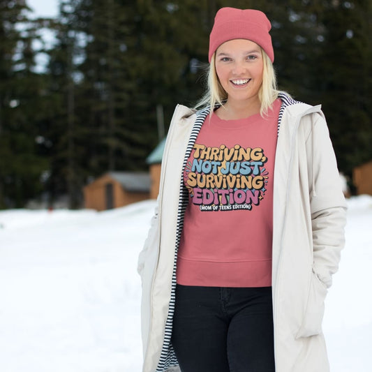 Person wearing a pink sweatshirt with text in a snowy outdoor setting