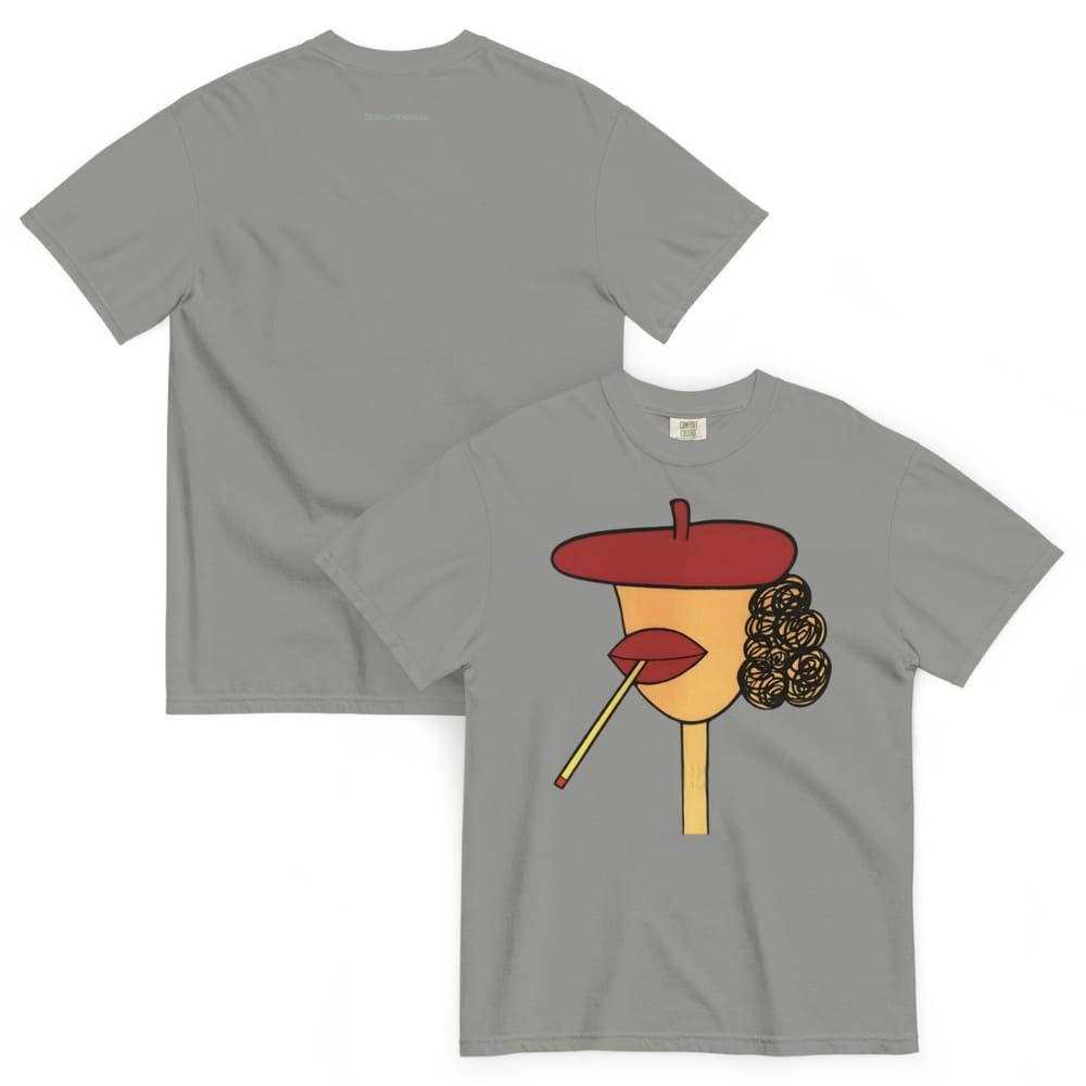Gray t-shirt with a graphic design of a face wearing a red beret, yellow lipstick, and black hair on a white background.
