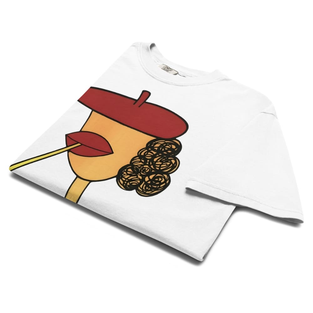 White t-shirt with a colorful graphic design of a face with a red beret and yellow lip on a white background