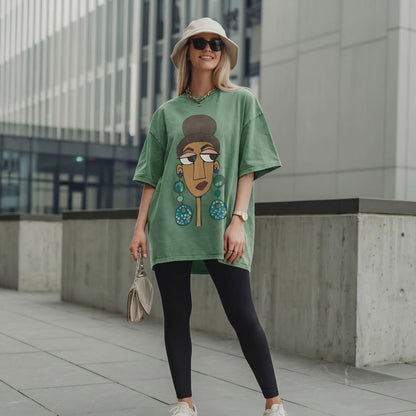 Woman wearing a green oversized t-shirt with a graphic design, standing in an urban setting.