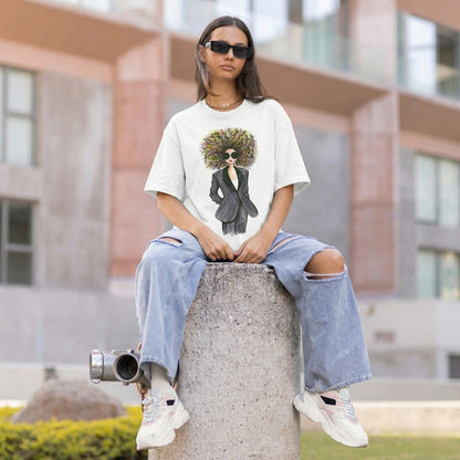 Person wearing a t-shirt with a graphic design of a person in a suit and sunglasses, sitting on a concrete block outdoors.