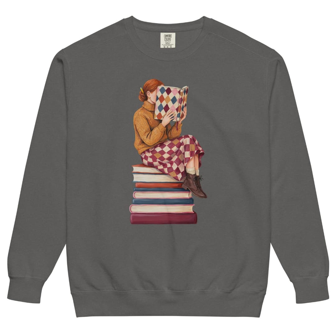 Between Chapters™ sweatshirt by Blossombless.co in Pepper, front view: a painterly woman perched on a stack of books, her face hidden behind a harlequin hardcover