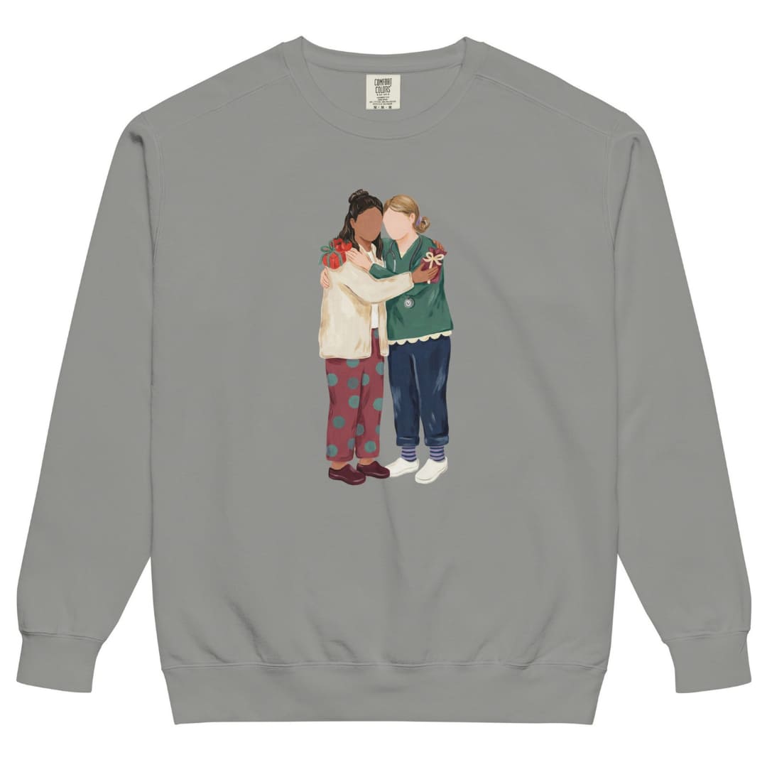 Charted With Love™ sweatshirt by Blossombless.co in Grey, front view: two nurse friends hugging, each hiding a wrapped gift, in a soft gouache style with a stethoscope, striped compression socks and clogs