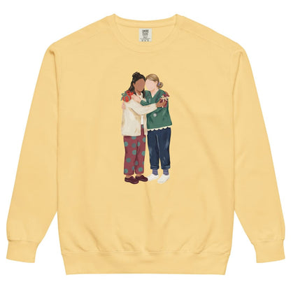 Charted With Love™ sweatshirt by Blossombless.co in Butter, front view: two nurse friends hugging, each hiding a wrapped gift, in a soft gouache style with a stethoscope, striped compression socks and clogs
