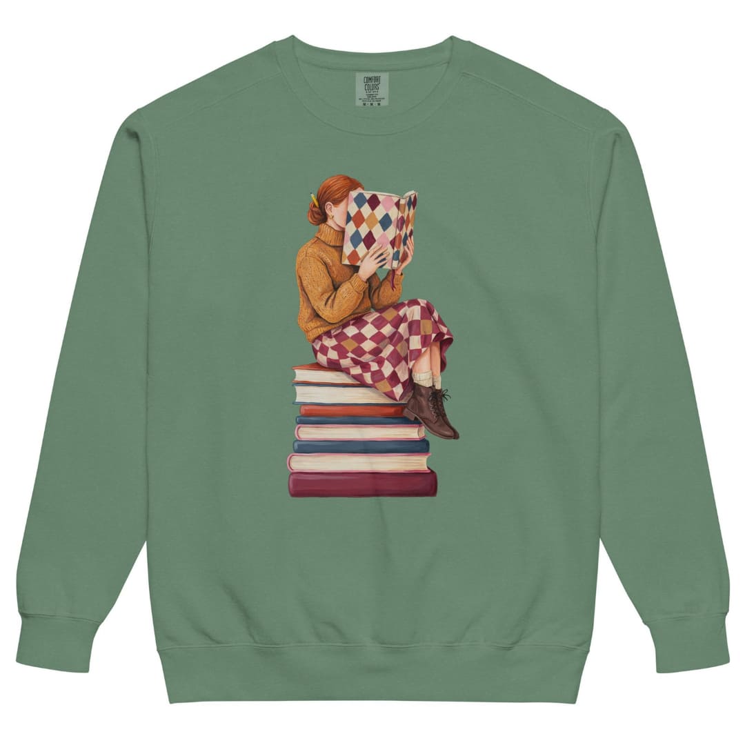 Between Chapters™ sweatshirt by Blossombless.co in Light Green, front view: a painterly woman perched on a stack of books, her face hidden behind a harlequin hardcover
