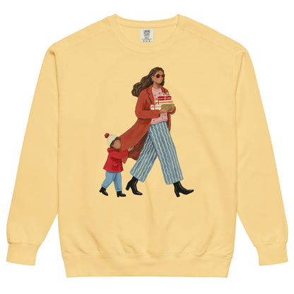Wrapped & Running™ sweatshirt by Blossombless.co in Butter, front view: a mom in a long red coat and red sunglasses carrying wrapped gifts, her toddler holding the hem of her coat, in a soft gouache style