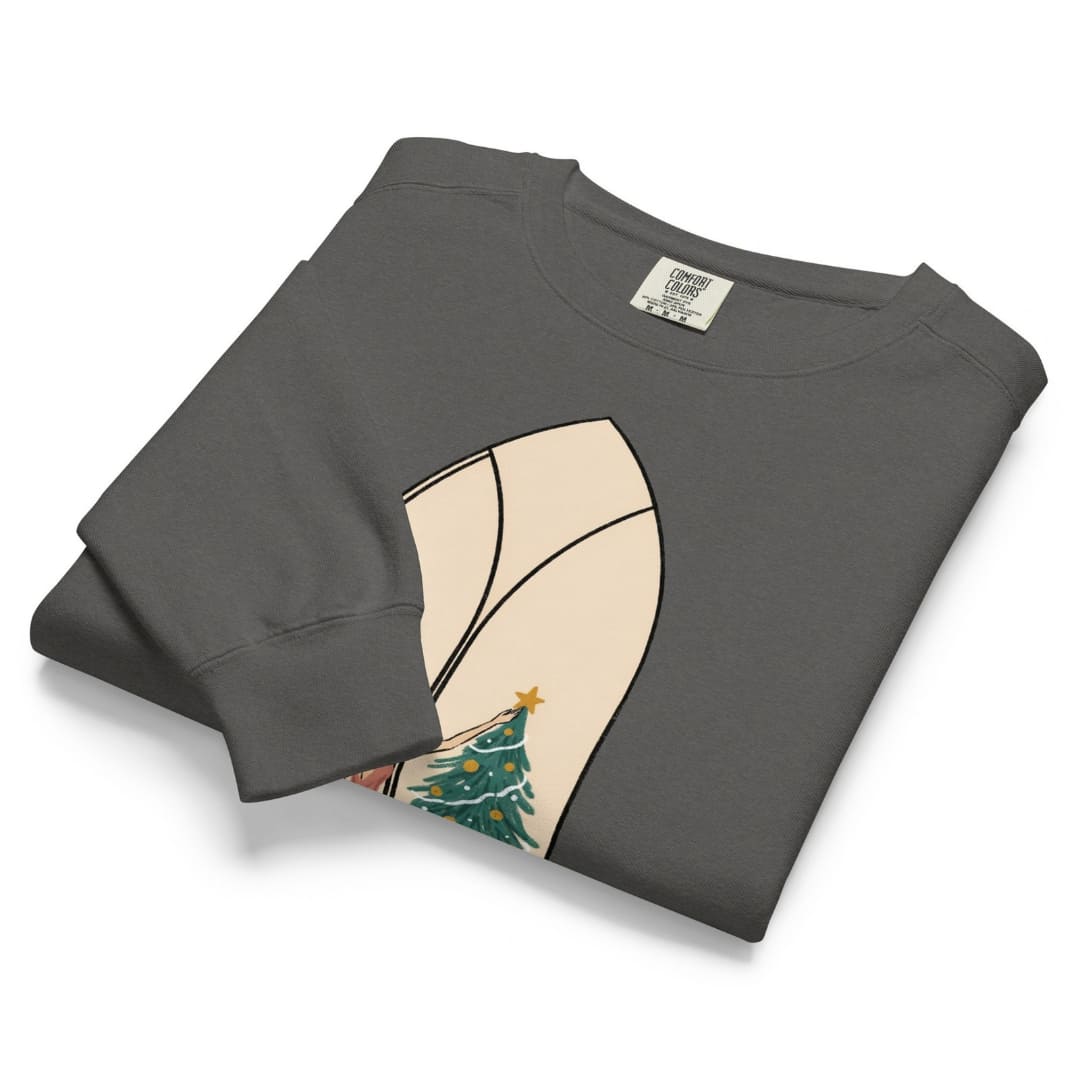 Star of the Season™ sweatshirt by Blossombless.co in Pepper, neatly folded to show the garment-dyed fleece and a soft pastel illustration of a woman in a backless rose gown placing a gold star on a Christmas tree, framed inside an ivory gothic arched window