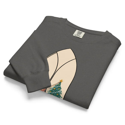 Star of the Season™ sweatshirt by Blossombless.co in Pepper, neatly folded to show the garment-dyed fleece and a soft pastel illustration of a woman in a backless rose gown placing a gold star on a Christmas tree, framed inside an ivory gothic arched window