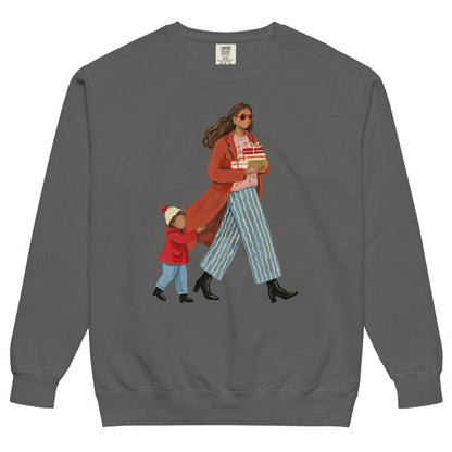 Wrapped & Running™ sweatshirt by Blossombless.co in Pepper, front view: a mom in a long red coat and red sunglasses carrying wrapped gifts, her toddler holding the hem of her coat, in a soft gouache style