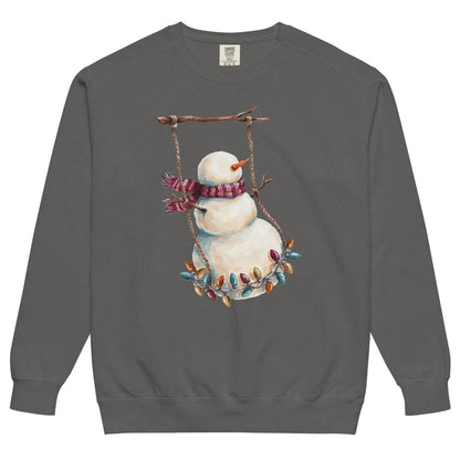 Swing Season™ sweatshirt by Blossombless.co in Pepper, front view: a painterly snowman swinging on a strand of vintage Christmas lights from a bare winter branch, wearing a striped burgundy scarf