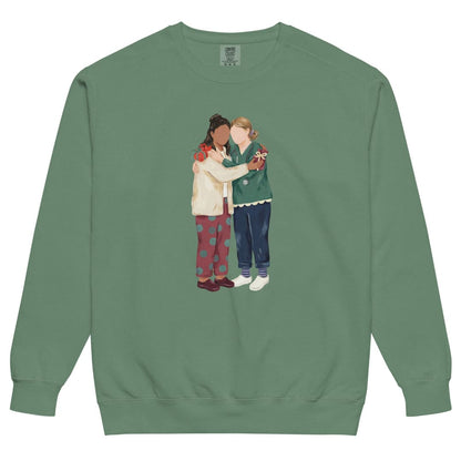 Charted With Love™ sweatshirt by Blossombless.co in Light Green, front view: two nurse friends hugging, each hiding a wrapped gift, in a soft gouache style with a stethoscope, striped compression socks and clogs
