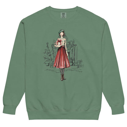 Holiday Muse™ sweatshirt by Blossombless.co in Light Green, front view: a sketch-style watercolor illustration of a faceless woman in a green beret, Fair Isle sweater and red pleated skirt holding a wrapped gift, with a loosely sketched fireplace and Christmas tree behind her