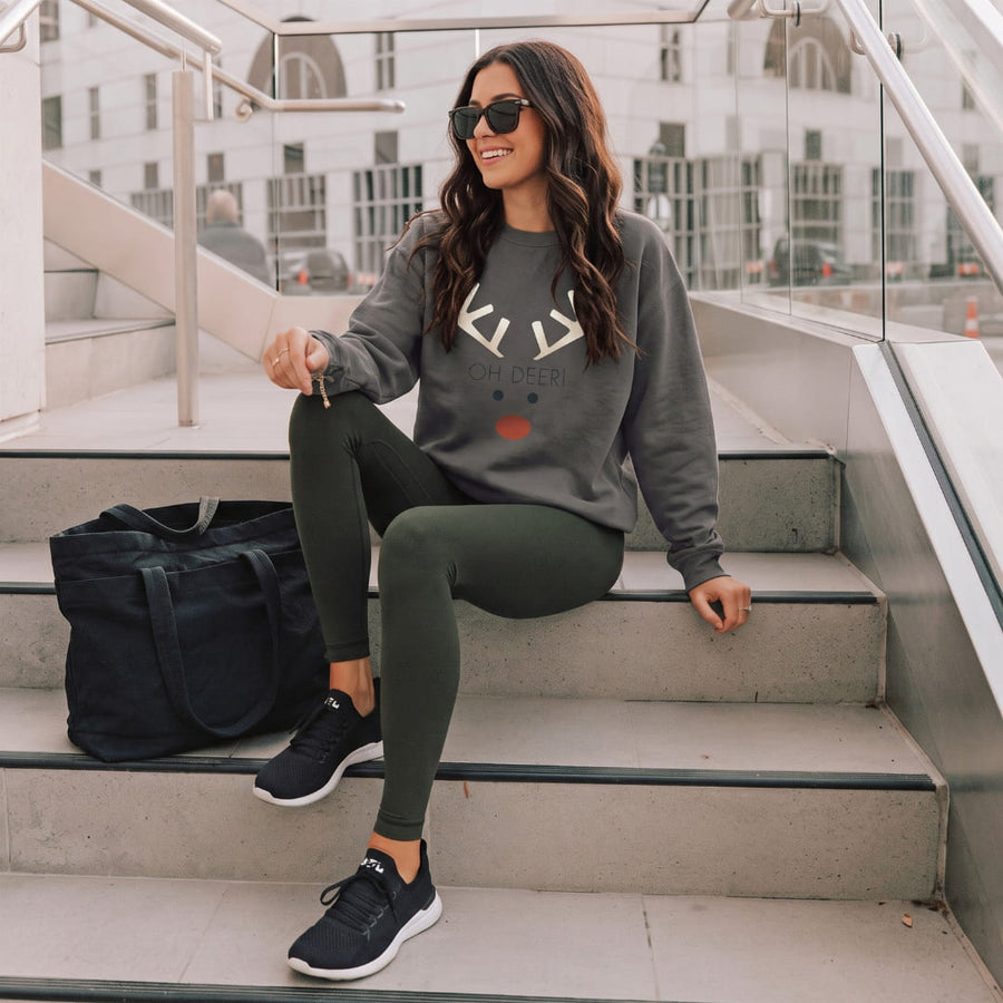 Oh Deer!™ sweatshirt by Blossombless.co in Pepper, lifestyle: woman in dark leggings seated on outdoor stone steps