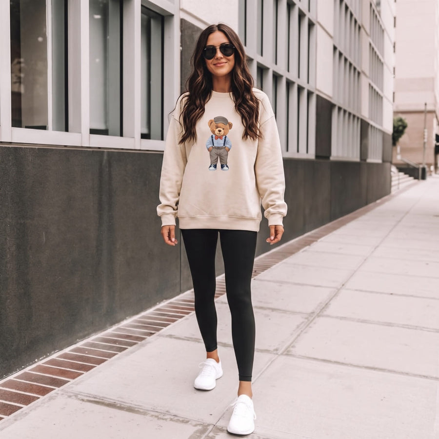 Classic Teddy Bear™ oversized sweatshirt by Blossombless.co in Dust, lifestyle: woman in black leggings and sunglasses walking on a city sidewalk