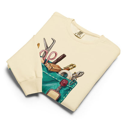 The Shift Pocket™ sweatshirt in Ivory, folded flat with the hand-painted scrub pocket design on the chest