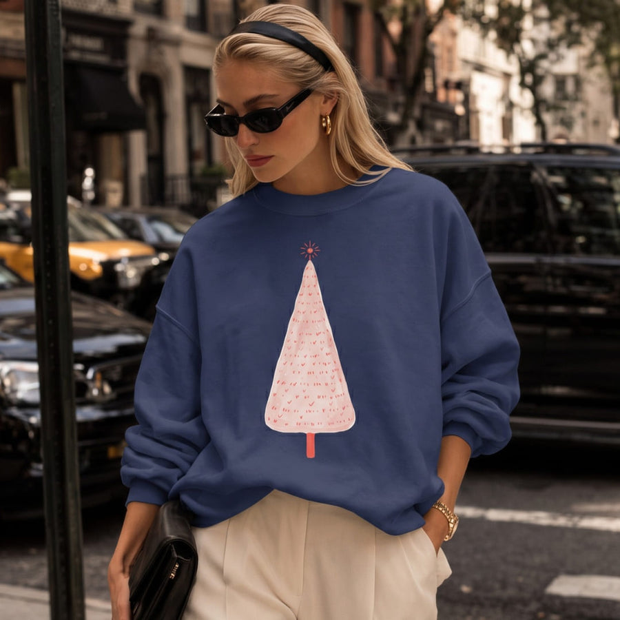Woman wearing the Pink Pine™ sweatshirt by Blossombless.co in True Navy with cream trousers and sunglasses, walking down a city street