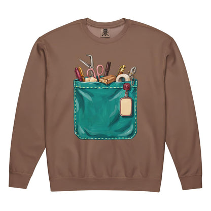 The Shift Pocket™ nurse sweatshirt in Espresso, front view: hand-painted teal scrub pocket holding trauma shears, a hemostat, pens, tape and a badge reel