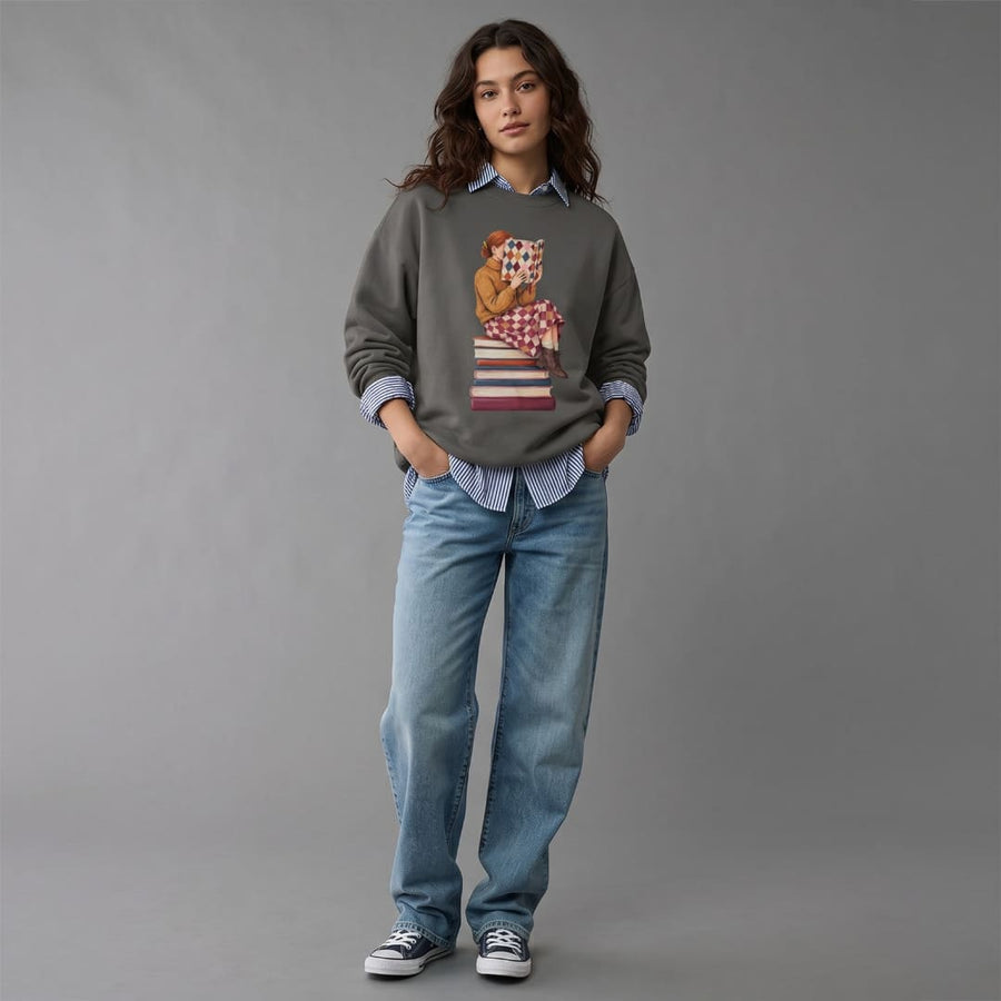 Woman wearing the Between Chapters™ sweatshirt by Blossombless.co in Pepper with light-wash wide-leg jeans and sneakers, standing against a gray studio wall