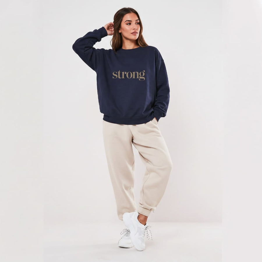 Strong™ oversized sweatshirt by Blossombless.co in Navy, lifestyle: woman in beige trousers against a clean white backdrop