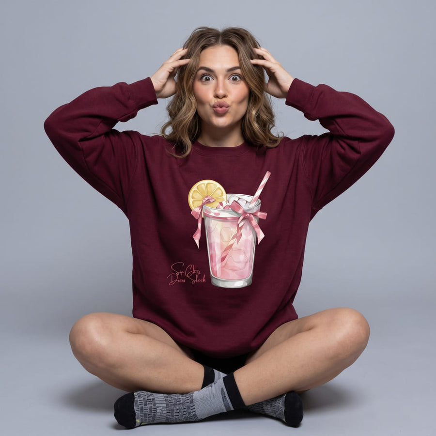 Sip Chic™ oversized sweatshirt by Blossombless.co in Maroon, lifestyle: woman seated cross-legged against a gray studio backdrop