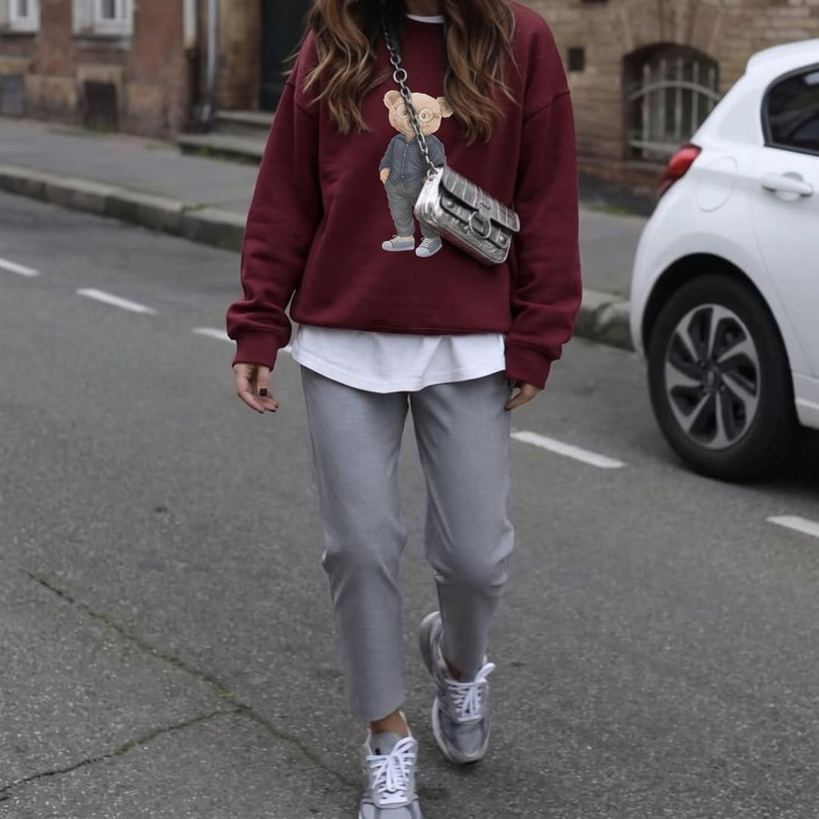 Professor Theo™ oversized sweatshirt by Blossombless.co in Maroon, lifestyle: woman in gray trousers with a crossbody bag on a city street