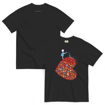 Black t-shirt with a colorful heart design and a small figure on a white background