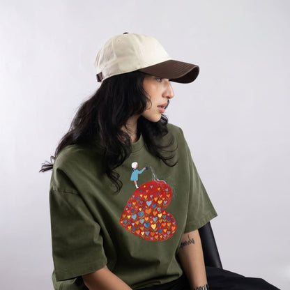 Person wearing a green sweatshirt with a colorful graphic design on a plain background