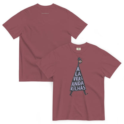 A dusty rose short-sleeve t-shirt shown from both front and back. The front features a graphic of a dark blue inverted triangle with the text 'A LA VRAS ANDA RILHAS' in white, topped with a small black-and-white bird.