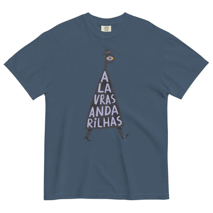 A slate blue crewneck t-shirt featuring a graphic of a dark silhouette shaped like the letter 'A', with a single eye on its head and the Portuguese text 'A LA VRAS ANDA RILHAS' printed in white inside the silhouette.