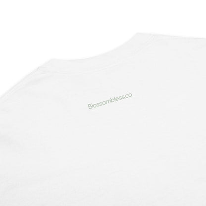 Close-up of a white crewneck t-shirt with the brand name 'Blossomblessco' printed in a light sage green font on the upper chest.