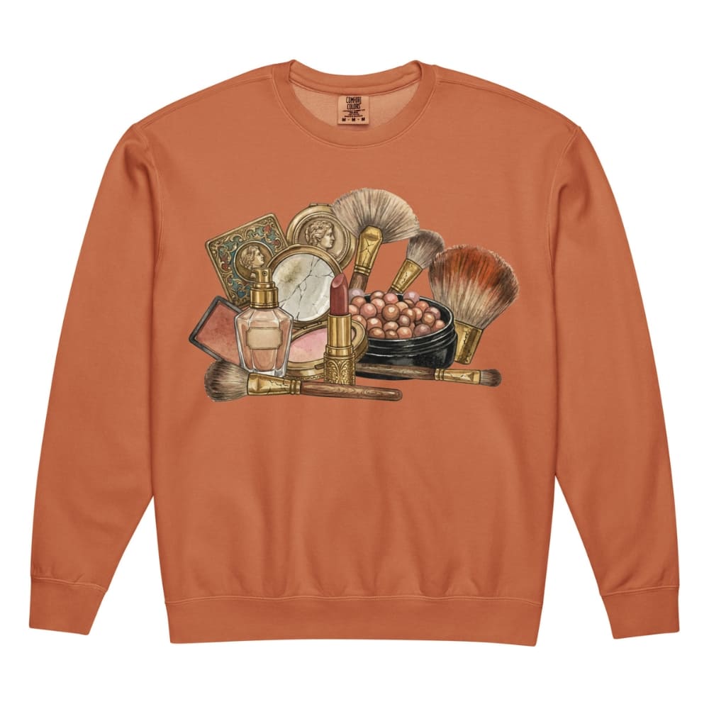 Orange sweatshirt with vintage makeup brush and product graphic on a white background