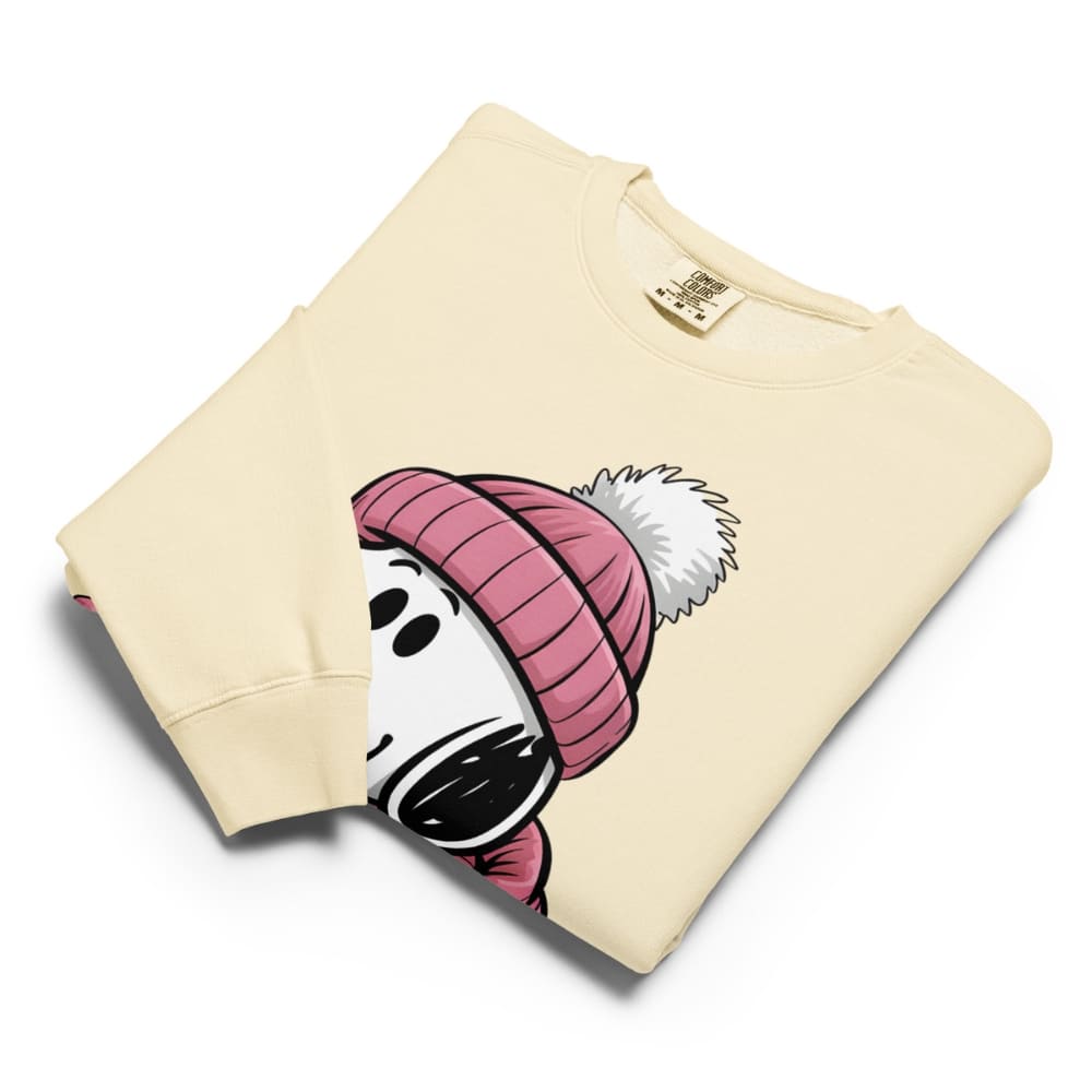 Folded beige sweatshirt with cartoon character wearing a pink beanie on a white background