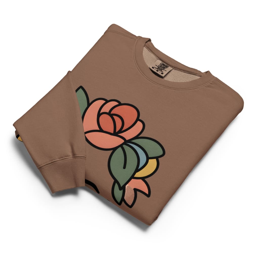 Folded brown sweatshirt with a colorful rose design on a white background