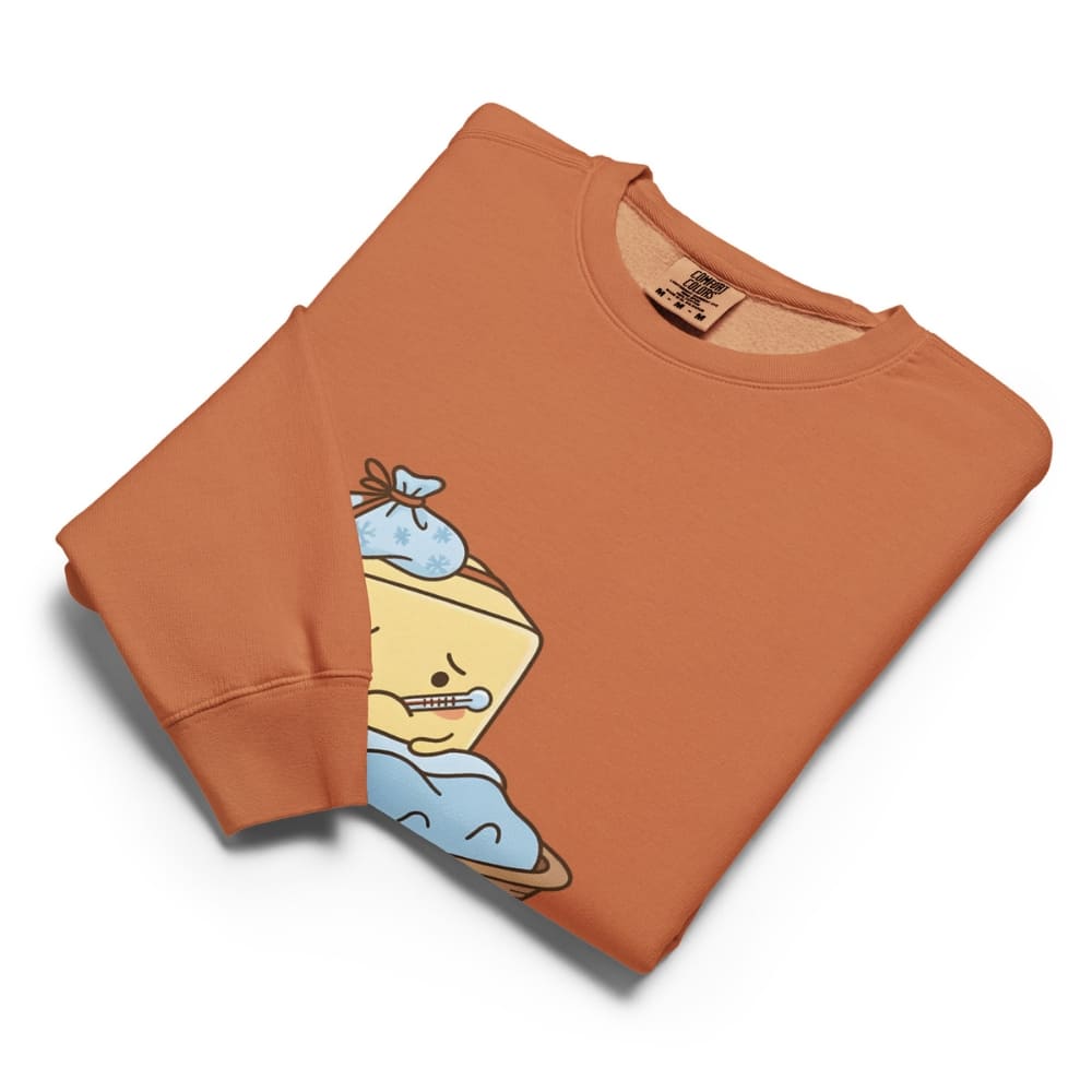 Folded orange sweatshirt with cartoon character design on a white background
