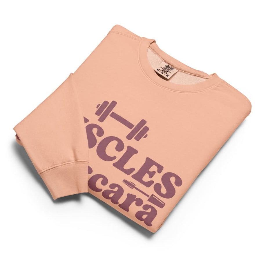 Folded peach-colored sweatshirt with purple text on a white background