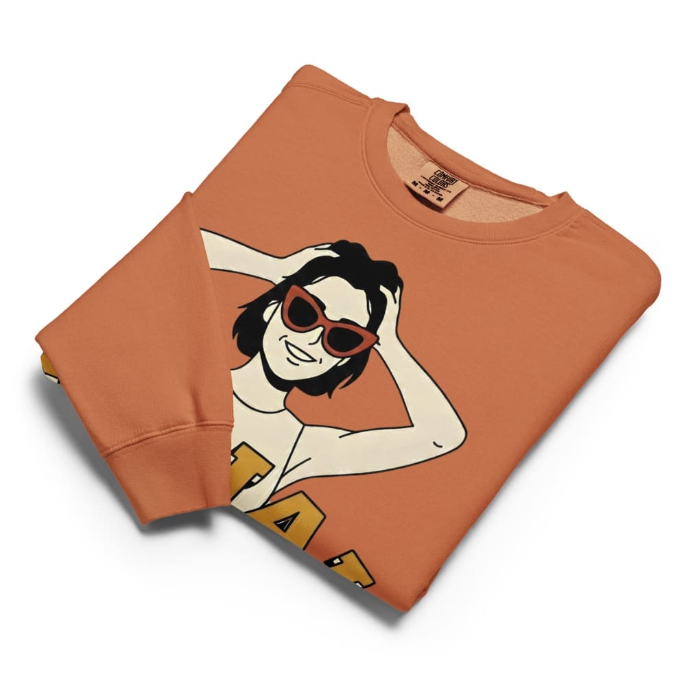 Folded orange sweatshirt with a graphic design on a white background
