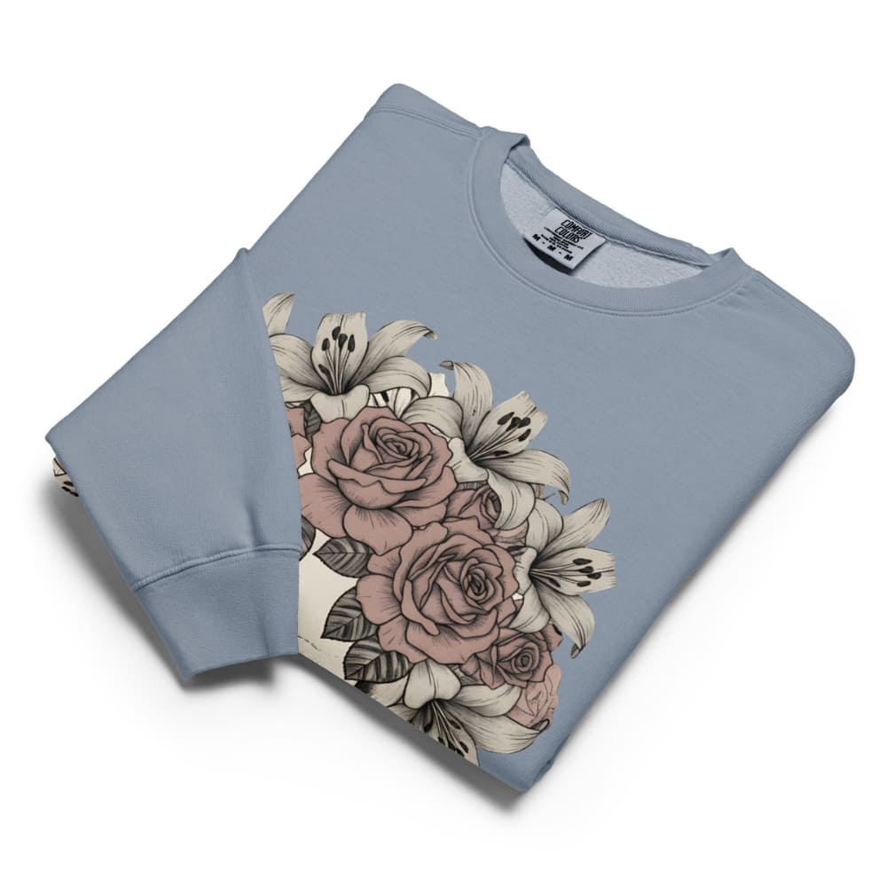 Folded light blue sweatshirt with floral design on a white background