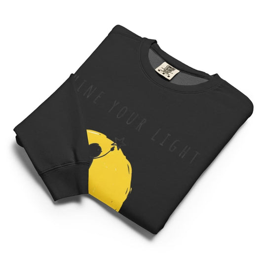 Black sweatshirt with yellow graphic and text 'Shine Your Light' on a white background