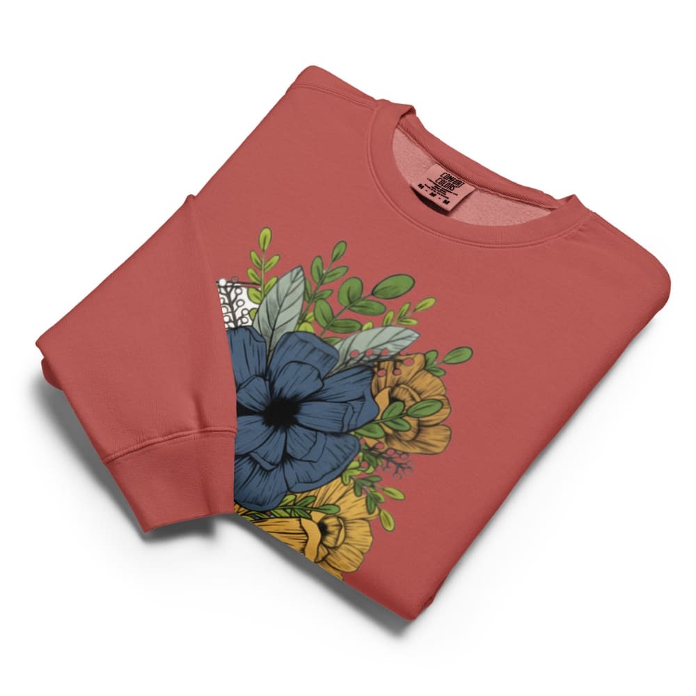 Folded red sweatshirt with floral design on a white background