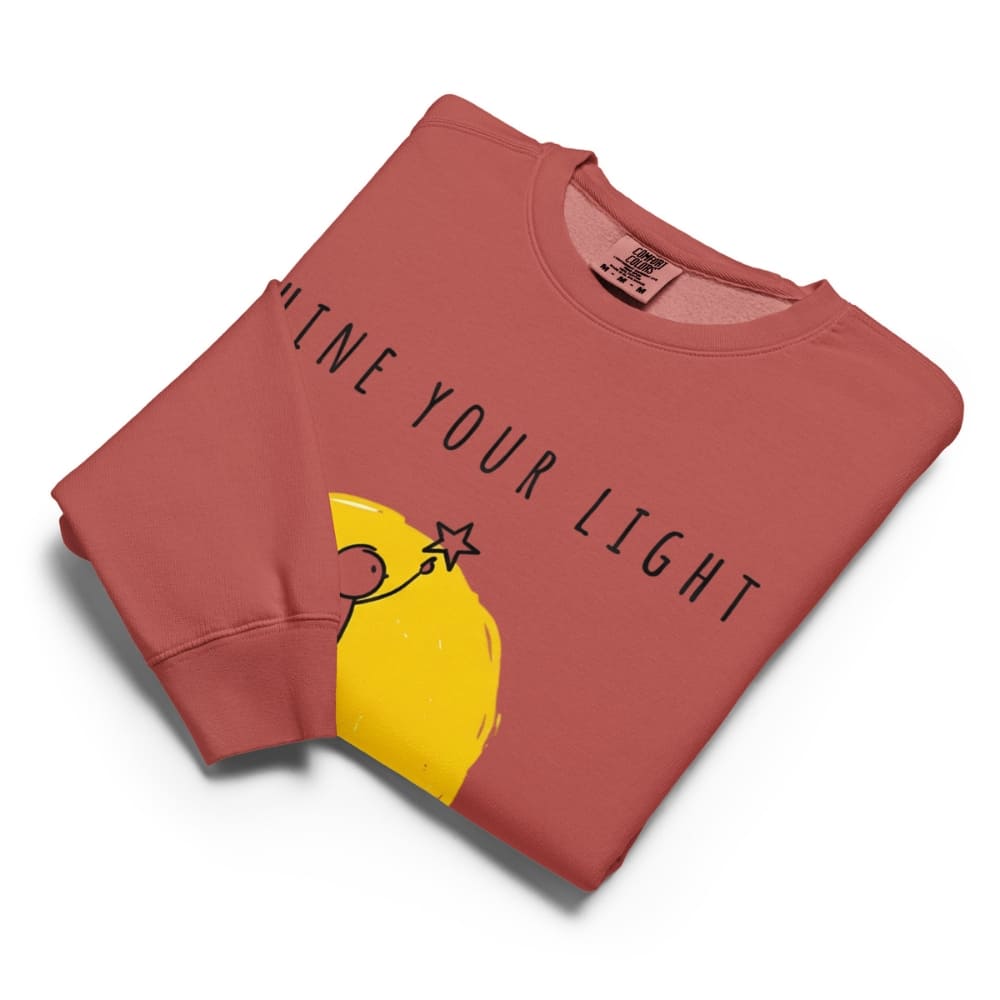 Folded red sweatshirt with yellow graphic and text on a white background