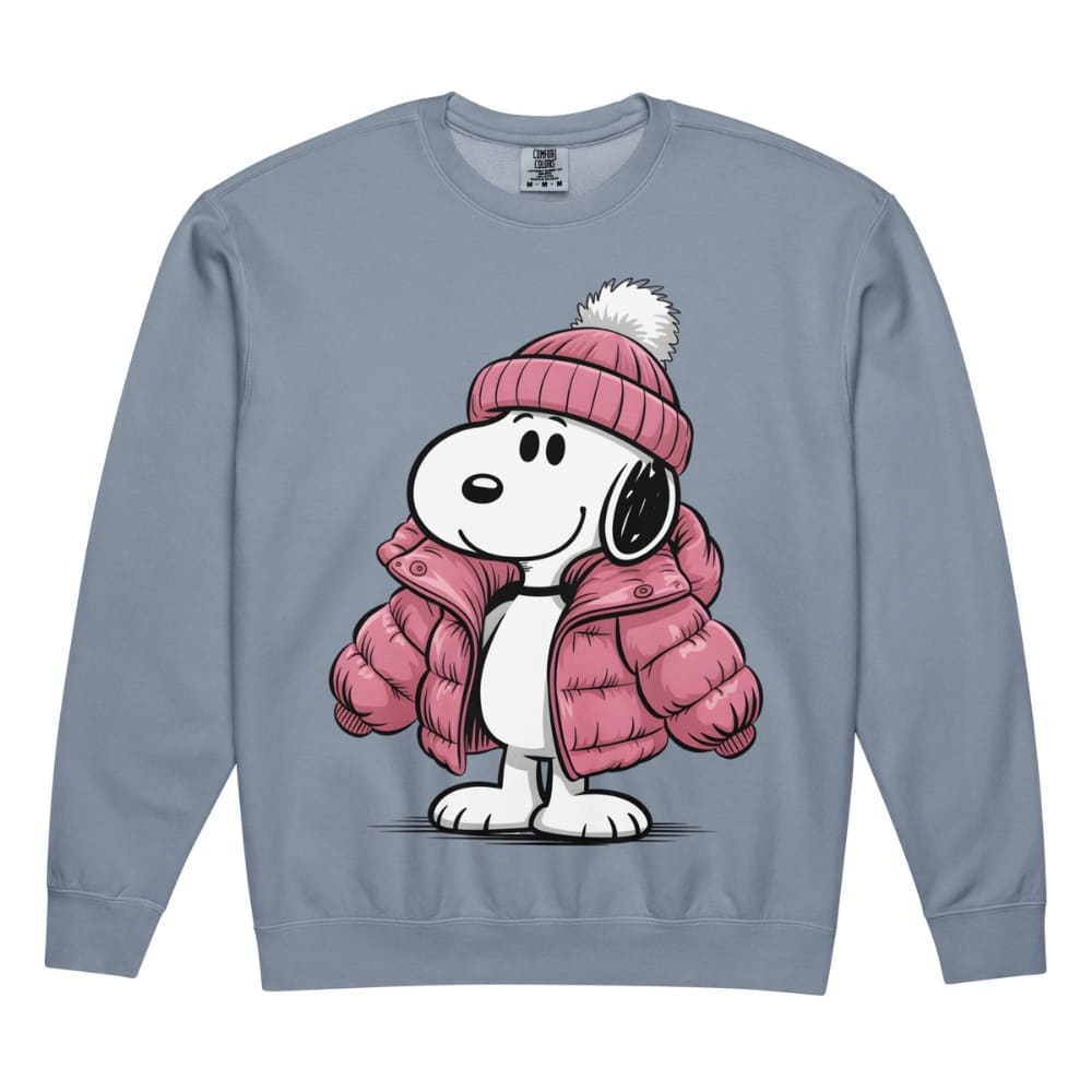 Snoopy wearing a pink winter coat and hat on a blue sweatshirt