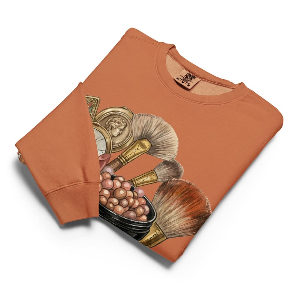 Orange sweatshirt with makeup brush design on a white background