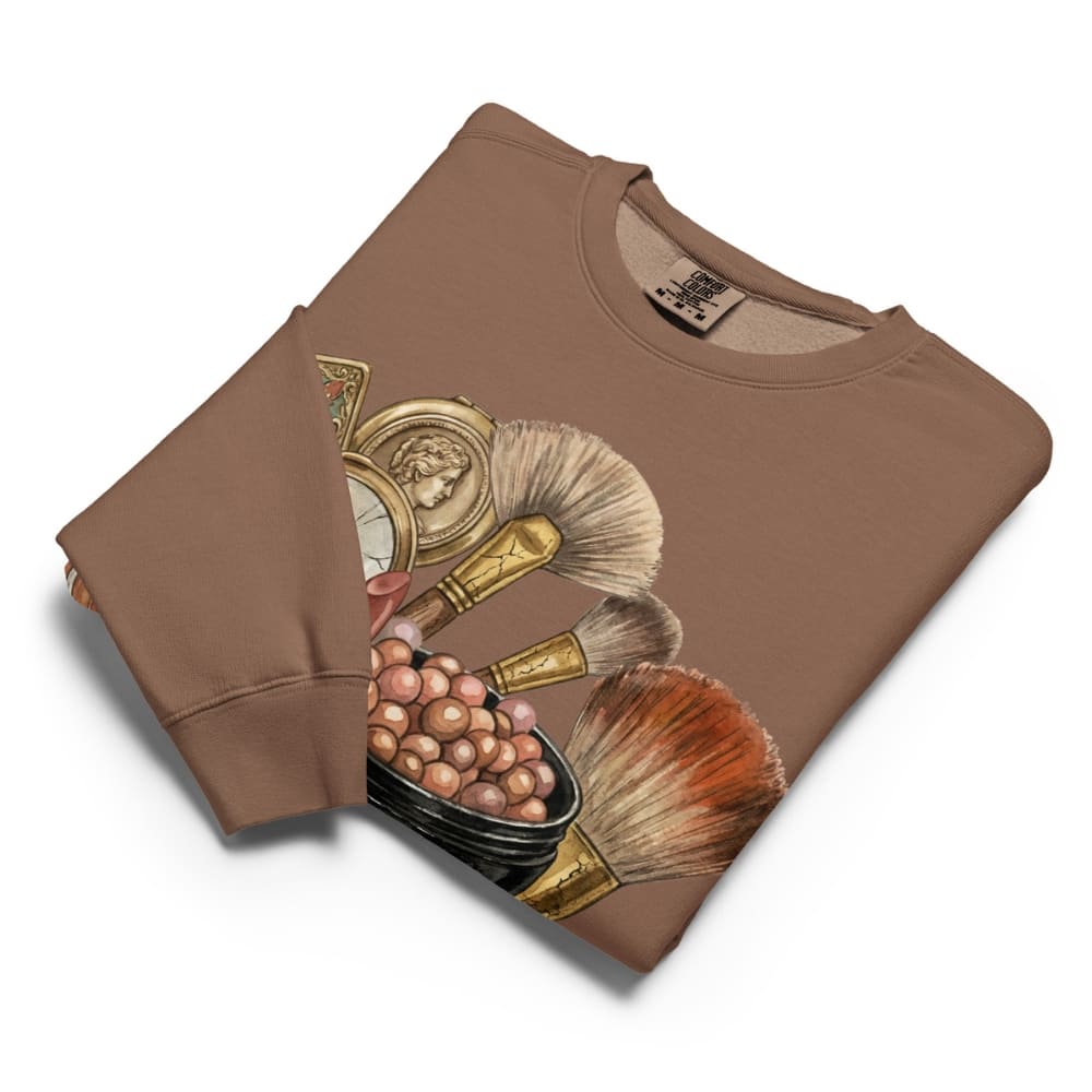 Folded brown sweatshirt with makeup brush design on a white background