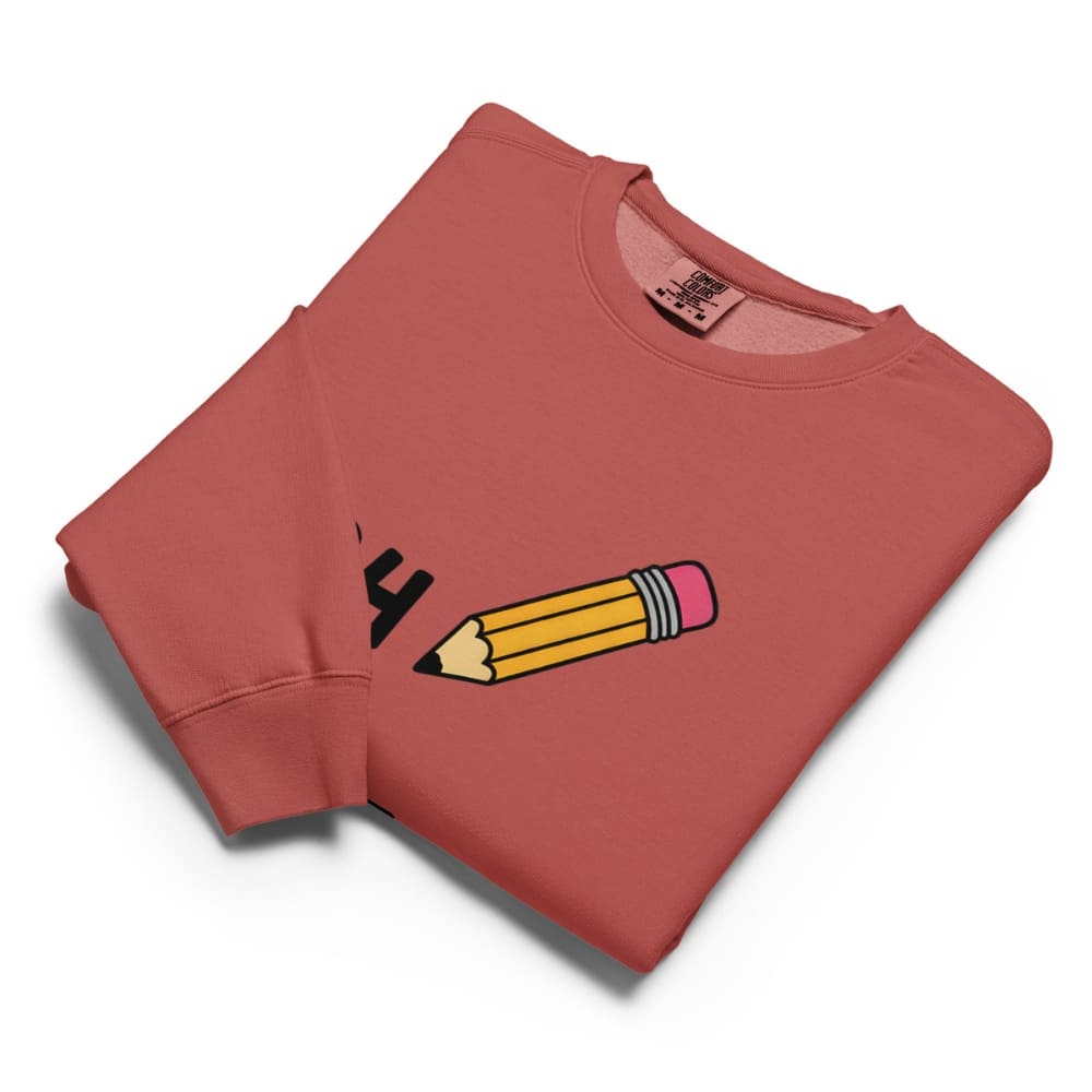 Folded red sweatshirt with a pencil graphic on a white background