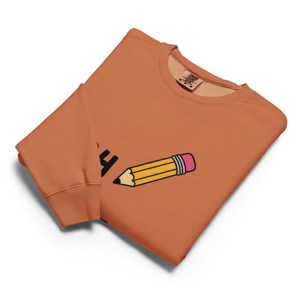 Folded orange sweatshirt with a pencil graphic on a white background