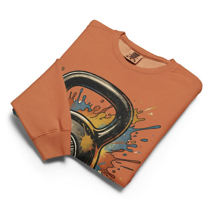 Folded orange sweatshirt with graphic design on a white background