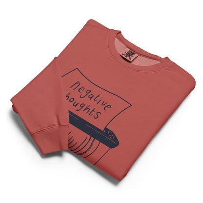 Folded terracotta-colored sweatshirt with 'negative thoughts' graphic on a white background