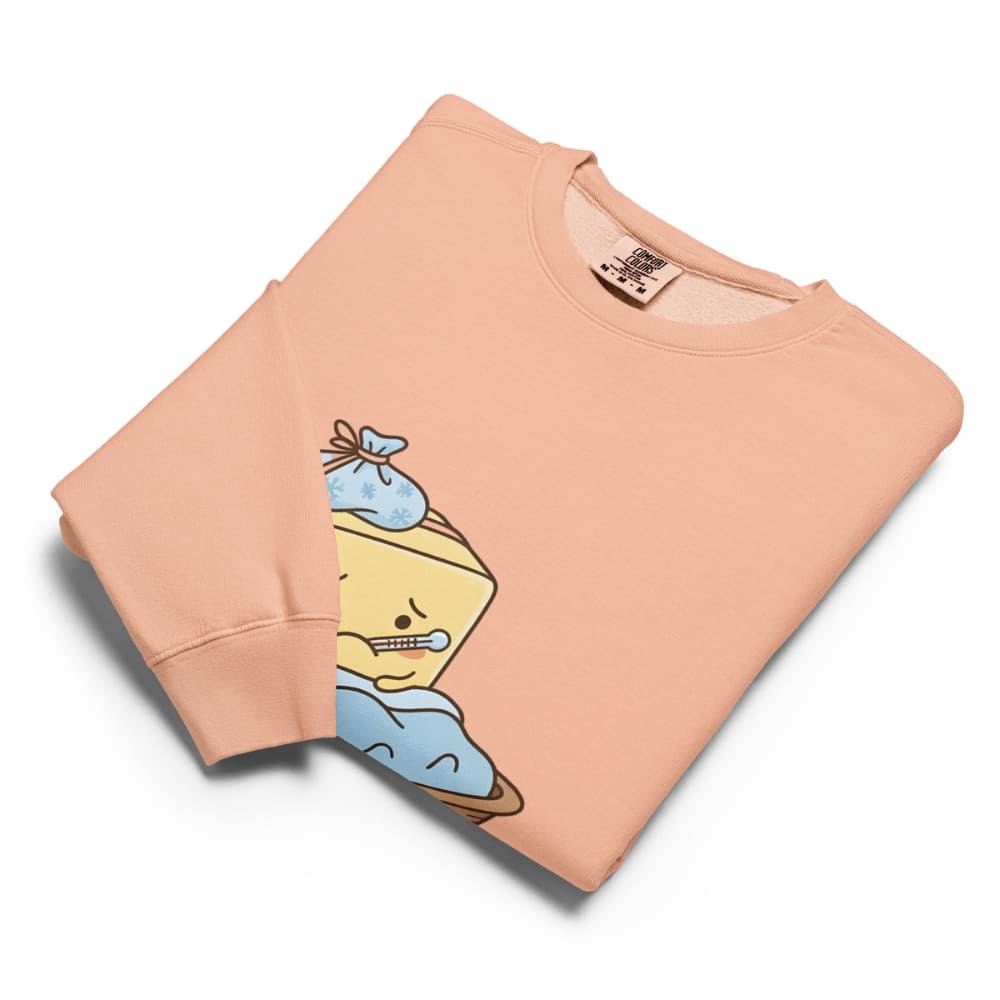 Folded peach-colored sweatshirt with cartoon character design on a white background